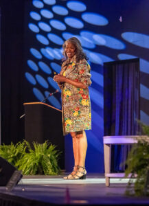 Leslie Maxie wearing her favorite color: yellow! She's on stage for her keynote at ROAR Alamance 2024.